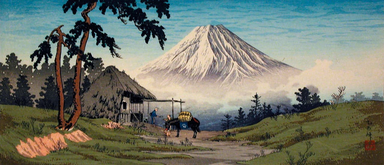 An ukiyo-e woodblock print of a road leading down into a valley. There is a small building with a thatched roof in the foreground with two figures and a horse outside of it. The road descends into a misty valley with a massive snow-covered mountain in the distance.